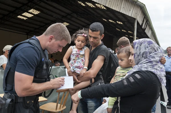 Une famille de réfugiés syriens accompagnée par un policier lors de son accueil en Allemagne.