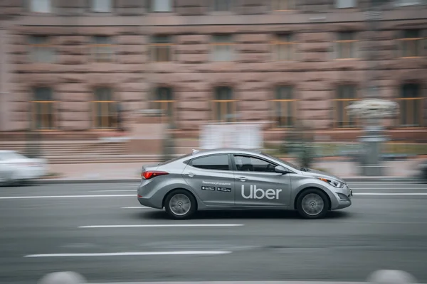 Un taxi Uber en mouvement dans une ville urbaine.