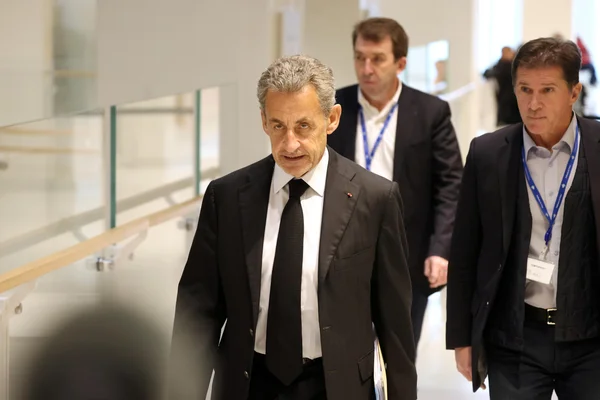 Nicolas Sarkozy se déplaçant dans un couloir.