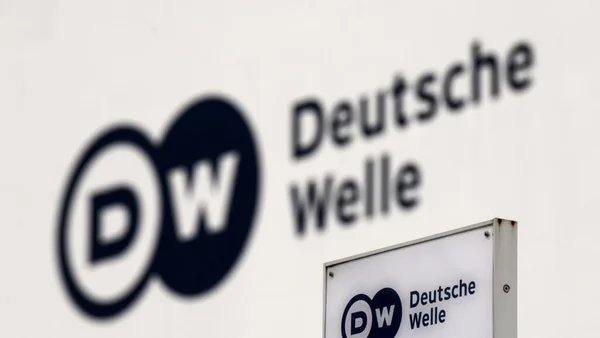 Portrait de l'écrivaine Asli Erdogan devant un micro en studio.