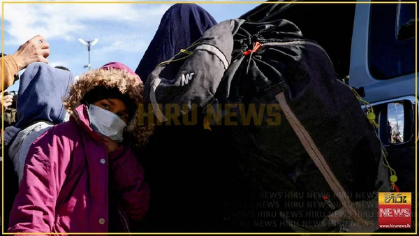 Un groupe de femmes, dont plusieurs portent un voile et un masque, sont rassemblées à l'extérieur.