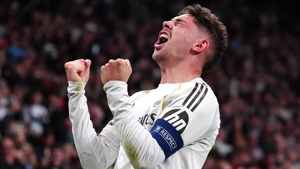 Un joueur du Real Madrid célébrant avec les poings levés devant la foule du stade.