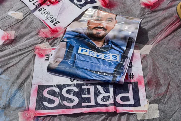 Un journaliste en gilet bleu dans une pièce ravagée par les tirs.