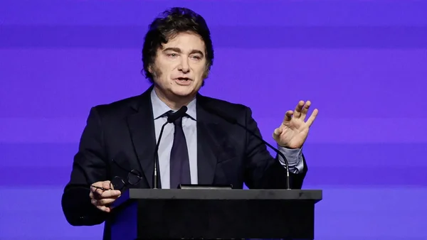 Un homme gesticulant à un podium.