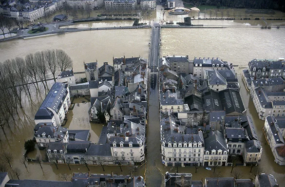 Vue aérienne de la ville d'Angers inondée en 1995 montrant les bâtiments et les rues sous l'eau.