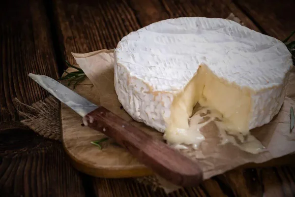 Un camembert affiné dont la pâte coule légèrement, prêt à être dégusté.
