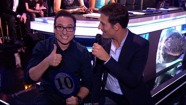 Jean-Marc Généreux avec une palette de note sur le plateau de télévision.