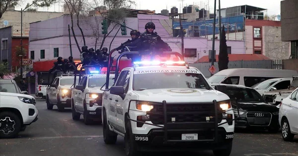 Un convoi de véhicules de la Garde nationale avec gyrophares et officiers armés.