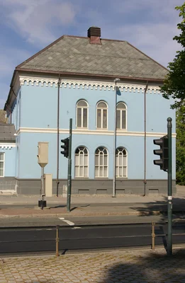 La synagogue de Trondheim à un carrefour, sous un ciel bleu dégagé.