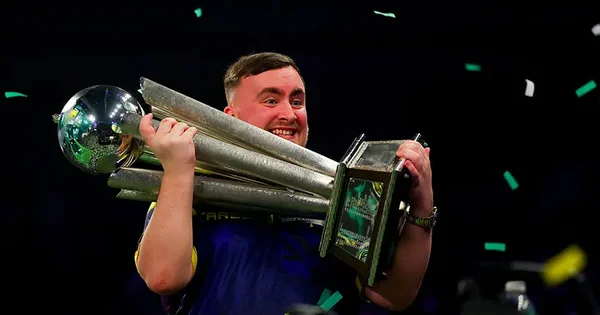 Squeezie triomphant avec un trophée au championnat du monde de fléchettes sous une pluie de confettis