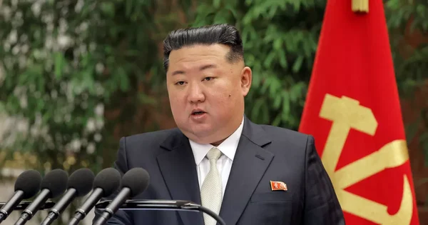 Un officiel nord-coréen s'adressant à la tribune devant un drapeau du parti lors du congrès.