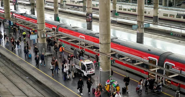 Train déraillé montrant une voiture couchée sur le côté et des débris au milieu de la végétation.