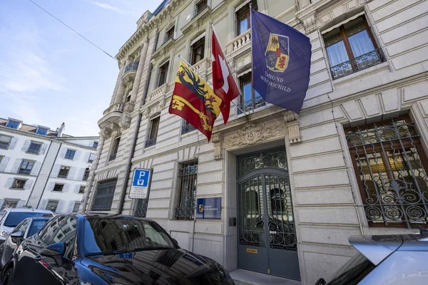 Bâtiment au numéro 18 arborant le drapeau suisse et la bannière bleue Edmond de Rothschild.