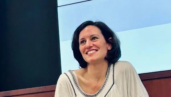 Magali Lafourcade s'exprimant, devant un public en salle aux sièges colorés.