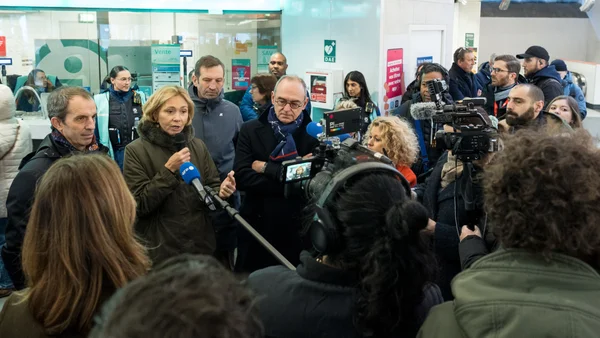 Une femme s'adresse à la presse sous les flashes des photographes.