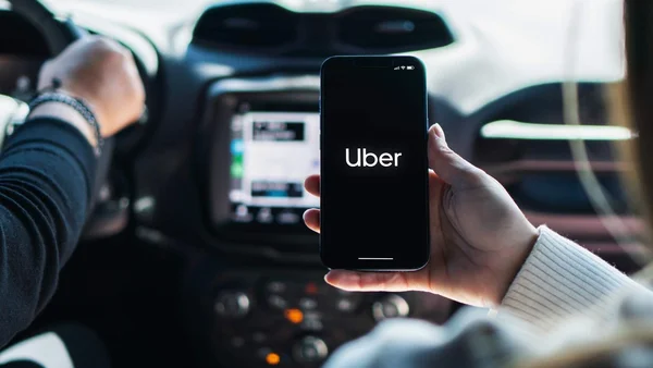 Un smartphone affichant le logo Uber à bord d'un véhicule.