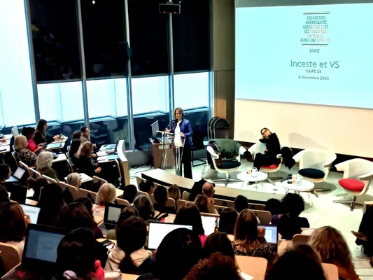 Intervenante de la Ciivise s'exprimant lors d'une conférence sur les violences sexuelles en Gironde, devant un public avec ordinateurs portables.