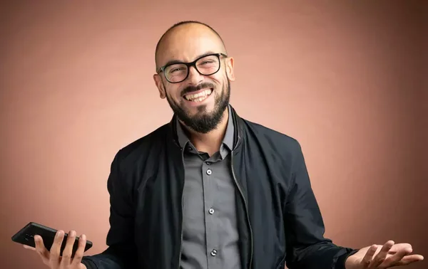 Jeremy Correia souriant, en chemise grise et veste sombre, devant un fond uni.