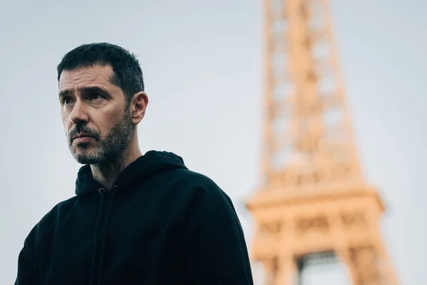 Photo de la série Privilèges montrant un homme devant la tour Eiffel en arrière-plan.