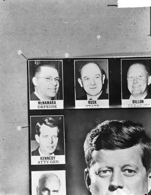 Panneau d'affichage avec les photographies de McNamara, Rusk, Dillon et Kennedy.