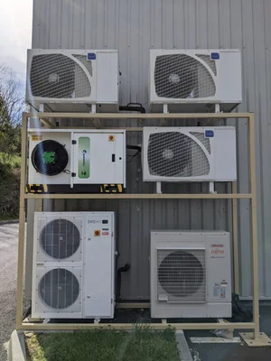 Pompes à chaleur de marques Fujitsu et Atlantic installées derrière la pharmacie de Lamure-sur-Azergues.