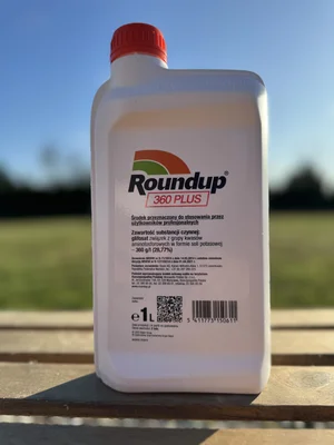 Une bouteille de Roundup 360 Plus avec étiquetage en polonais sur fond flou.