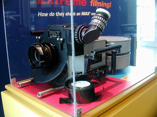 Une caméra de cinéma IMAX avec sa bobine de film exposée dans une vitrine.