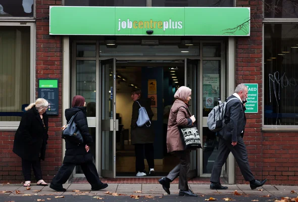 L'entrée d'un bâtiment Jobcentre Plus avec plusieurs personnes marchant sur le trottoir devant.