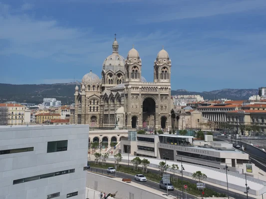 La Cathédrale de la Major vue depuis le Mucem à Marseille, avec ses coupoles caractéristiques et la ville en arrière-plan.