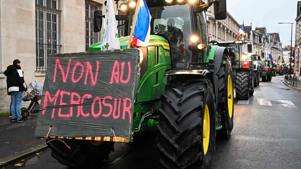 Un tracteur arborant une banderole 'NON AU MERCOSUR' lors d'une manifestation.
