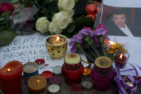 Des bougies et des fleurs, dont des roses blanches, déposées devant une photo lors d'un hommage à Boris Nemtsov.