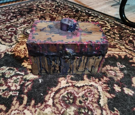 Une boîte en bois rustique avec de la cire fondue et le mot ABOUT écrit dessus.