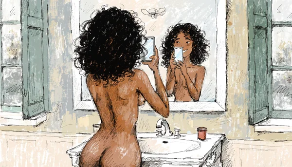 Femme nue prenant une photo d'elle-même avec son smartphone devant un miroir, lumière d'écran sur son visage