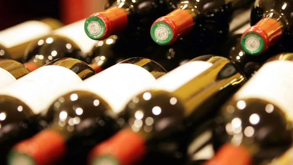 De multiples bouteilles de vin disposées en rangées sur des étagères.