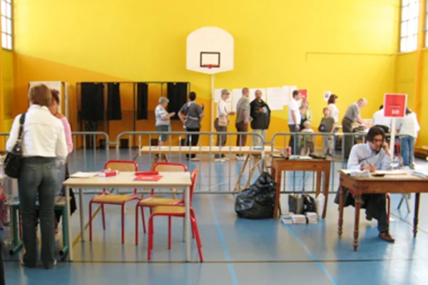 Préparation d'un lieu de vote dans un gymnase municipal.