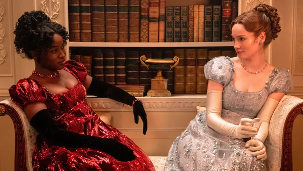 Les interprètes de Francesca et Michaela en costumes d'époque sur un canapé orné.