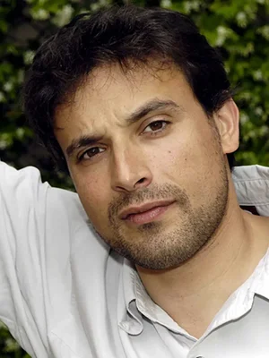 Bruno Salomone posant devant un fond de verdure.