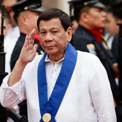 Homme discutant derrière un pupitre orné d'un emblème religieux.