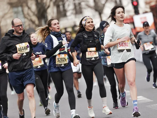 Groupes de coureurs avec dossards participant au Semi-marathon de Paris.