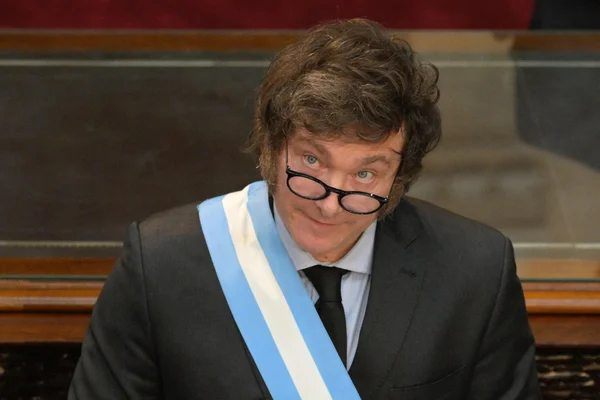 Le président Javier Milei portant l'écharpe présidentielle, en costume et chemise bleue claire.