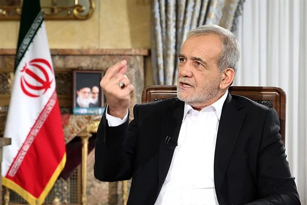 Le président iranien assis dans un fauteuil, avec un drapeau iranien visible derrière lui.