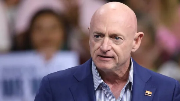 Le sénateur Mark Kelly en veste bleue sur fond flou.