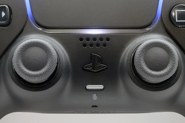 Une manette DualSense de PlayStation 5 édition Midnight Black montrant le logo, les sticks et le pavé tactile lumineux.