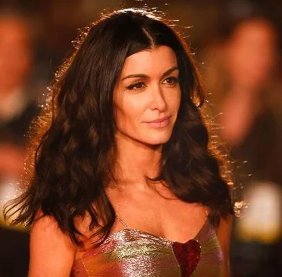 Jenifer Bartoli en robe métallique à motif cœur, gros plan sur fond flou.