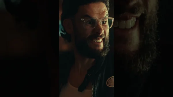 Un participant barbu et souriant au tournoi de fléchettes entre créateurs de LeBouseuh