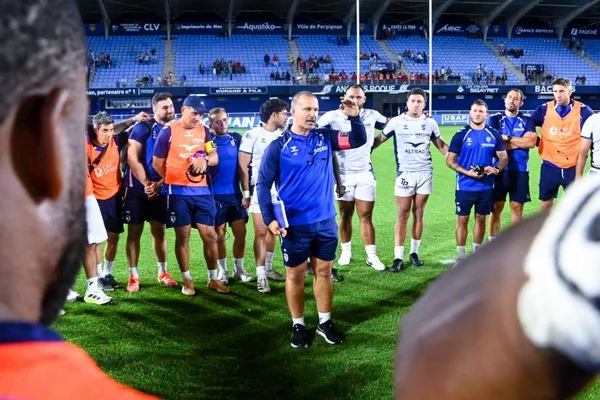 Entraîneur donnant des instructions tactiques à son équipe lors d'un entraînement.