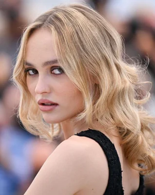 Portrait de Lily-Rose Depp, regard intense sur fond flou