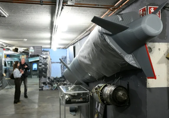 Le Berlin Story Bunker avec son enseigne lumineuse et le graffiti 'Wer bunker baut wirft Bomben'.