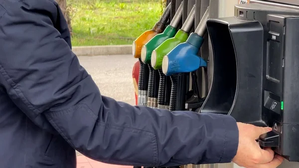 Un automobiliste paie son carburant à la pompe dans une station-service.