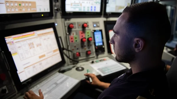 Un opérateur aux commandes dans le poste de pilotage du sous-marin.